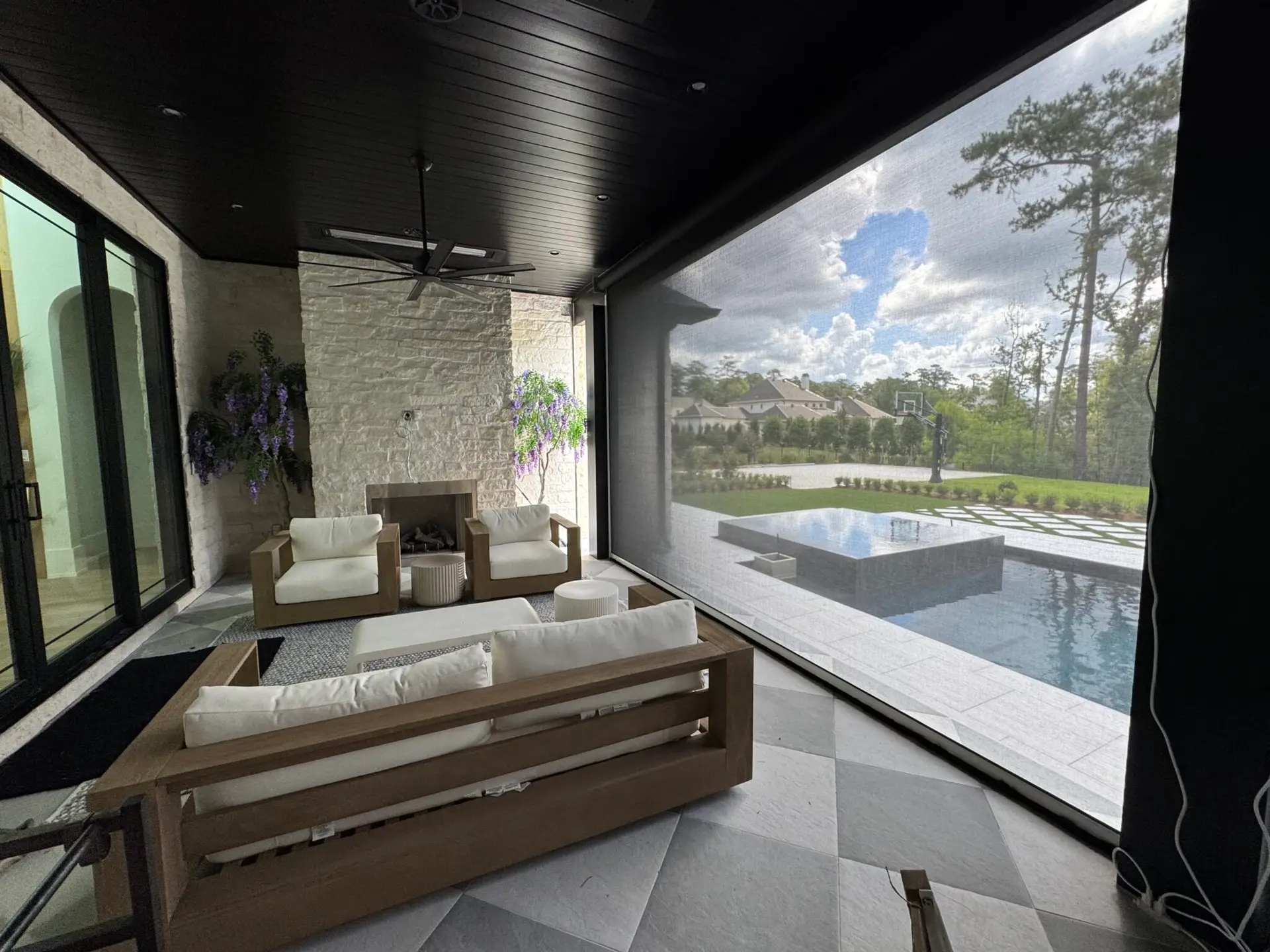 Luxury screened outdoor living area with fireplace and pool view